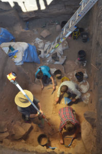 Archaeologists and students excavating the lowest reaches of the pit