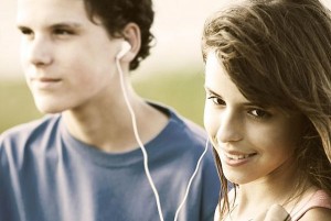 Teens listening through earbuds