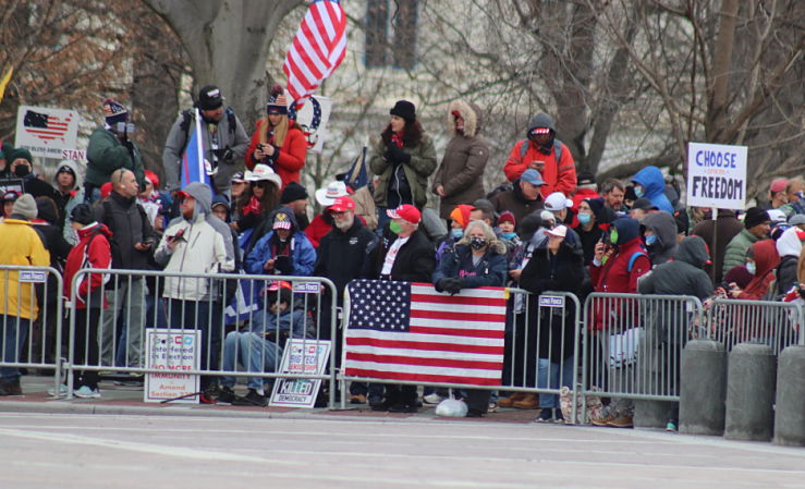 People at rally on January 6 leaning on barricades on East Capitol lawn before siege of capitol