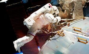 Astronaut floating in space working on repair to International Space Station