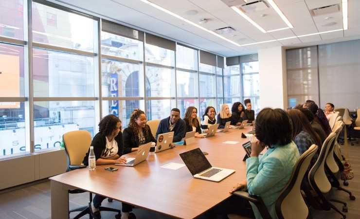 Photo: colleagues gathered around conference table.