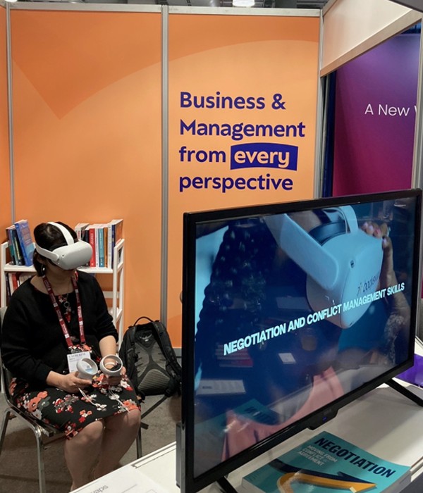 Women with VR headset and conference halyard sits for VR session on negotiation and conflict management skills