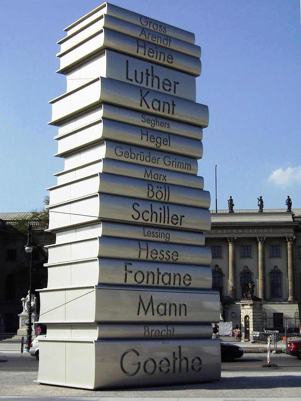 Several story high sculpture showing a stack of books by with names of German authors on their spines