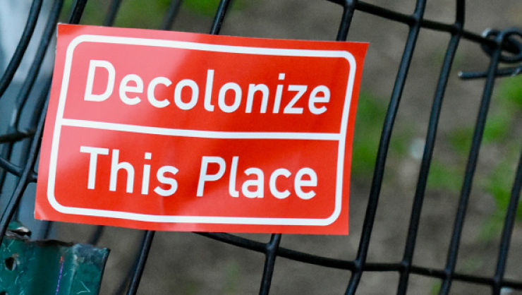 red sign that erads 'decolonize this place'
