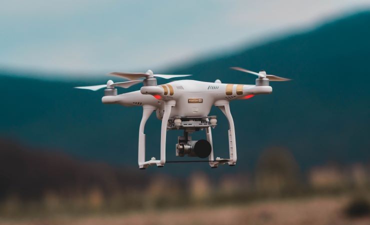 A drone hovers near a mountain.