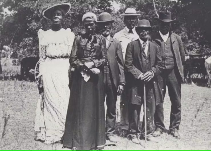 Outdoor group photo of four Black Mena and two Black women in formal clothing