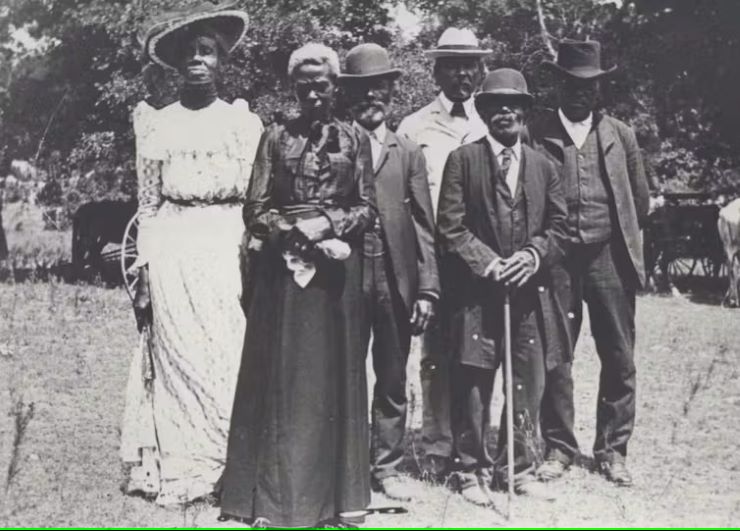 Outdoor group photo of four Black Mena and two Black women in formal clothing 