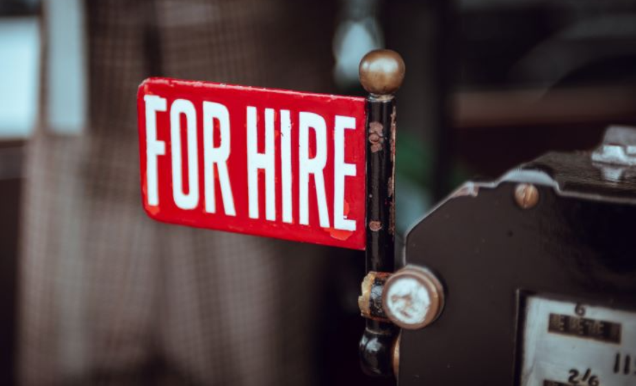 Photograph of red "For Hire" sign.