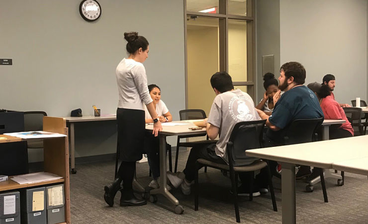 Margaret Ariotti standing before students at table