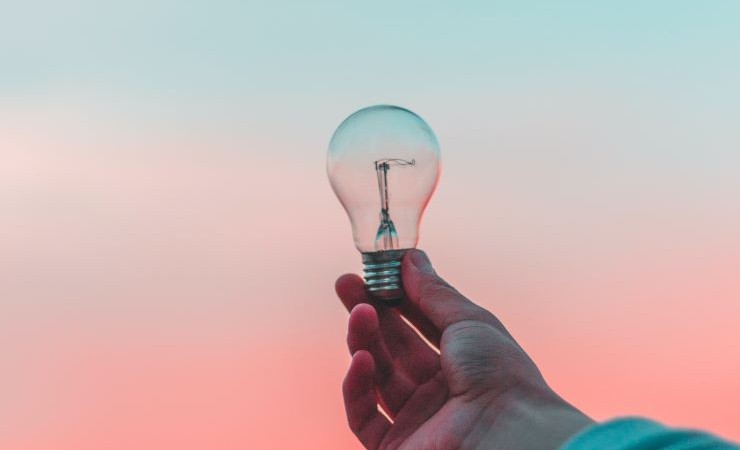 Close-up image of hand holding lightbulb.