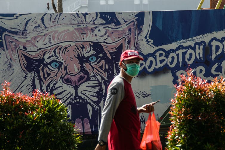 Food delivery worker wearing face mask in indonesia