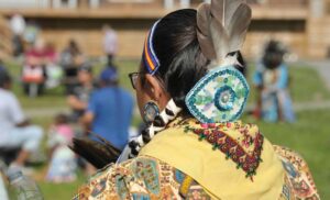 Woman seen from behind and dressed in clothing reflecting quebec first nations style