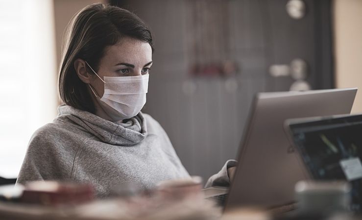 Masked woman using a laptop