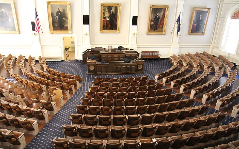 Empty government chamber with seats concentrically placed in semicircle and impressive desk at center