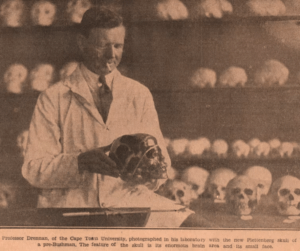 Matthew Drennan in lab coat hold skull in room full of skulls