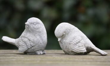 Ceramic birds in garden with one apparently ignoring the other