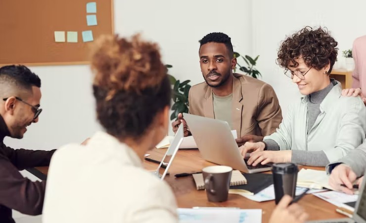 Young workers gathered around a table at office