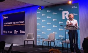 SSRC president Anna Harvey speaks into microphone on raised platform.