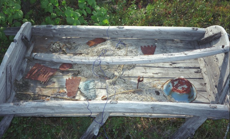 weathered wooden sleigh with several items sitting in it