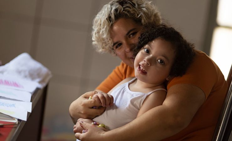 Mother cradles smiling 5-year-old girl