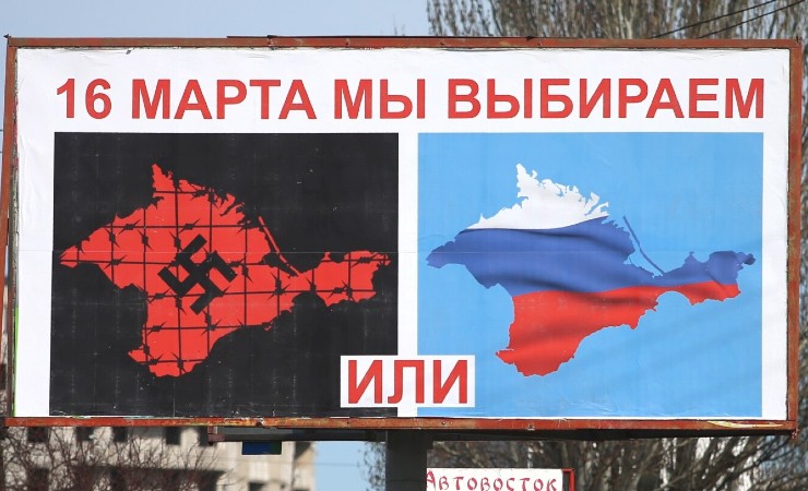 Billboard shows two outlines of Crimean peninsula, one with swastika and one with Russian flag