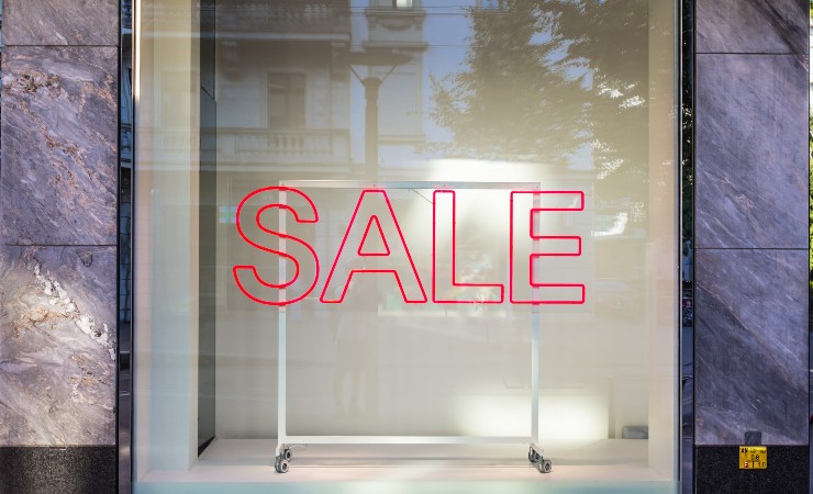 Empty shopfront window with red SALE decal.