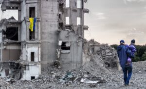 Artistic depiction of father carrying daughter past bombed-out building draped in Ukrainian flag