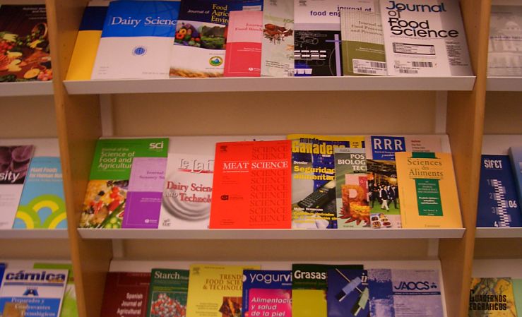 Library shelves with various journals lying flat