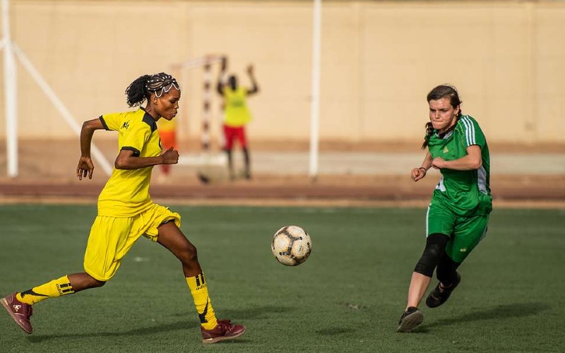 two players head for ball on football pitch