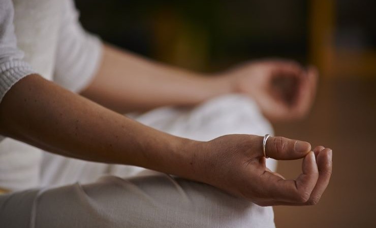 Close-up image of person sitting cross-legged doing yoga.