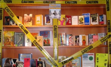Display of books with police 'caution' tape draped over them