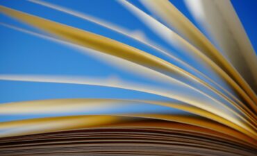 Book pages flipping against a blue background