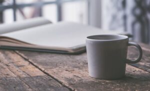 coffee mug on table with book