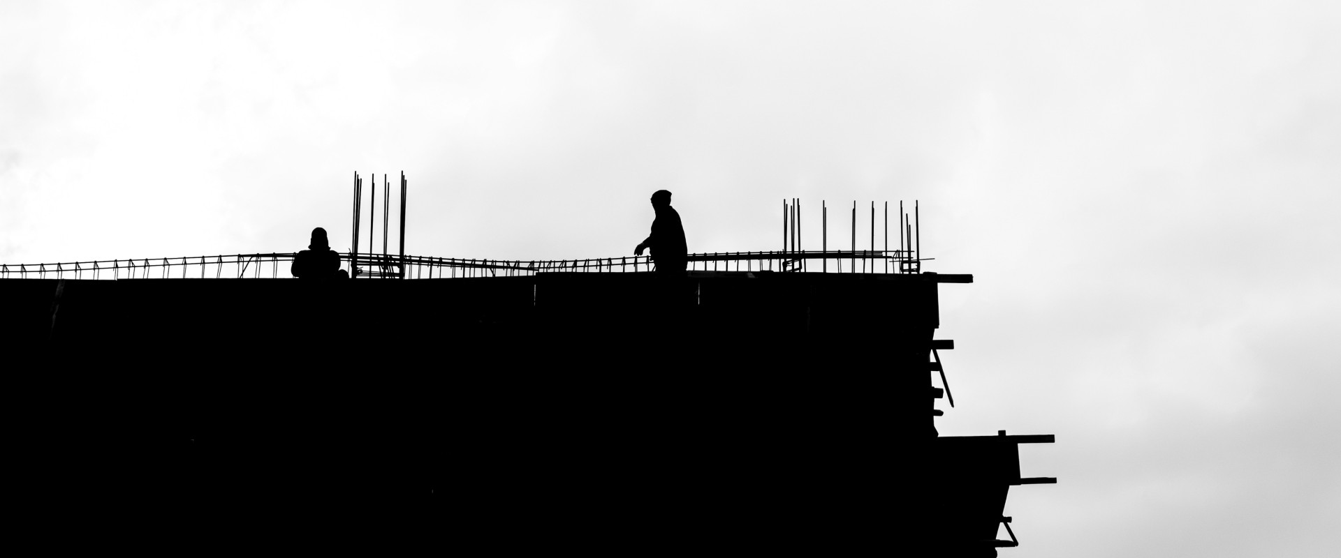 Silhouette of workers building large city building