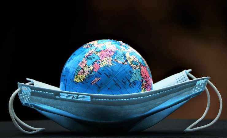 A protective mask cradles a globe