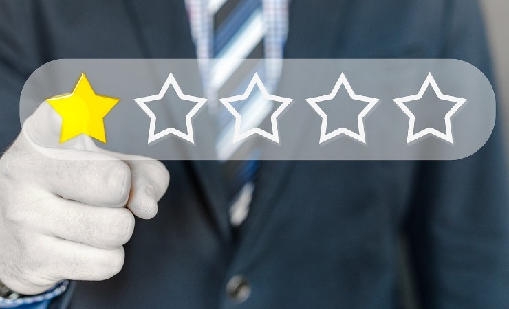 Finger pointing at single star on five-star review