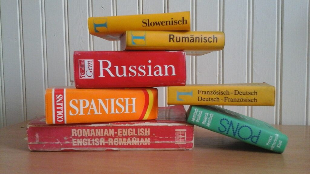 Photo shows textbooks for a variety of different languages stacked on top of each other.