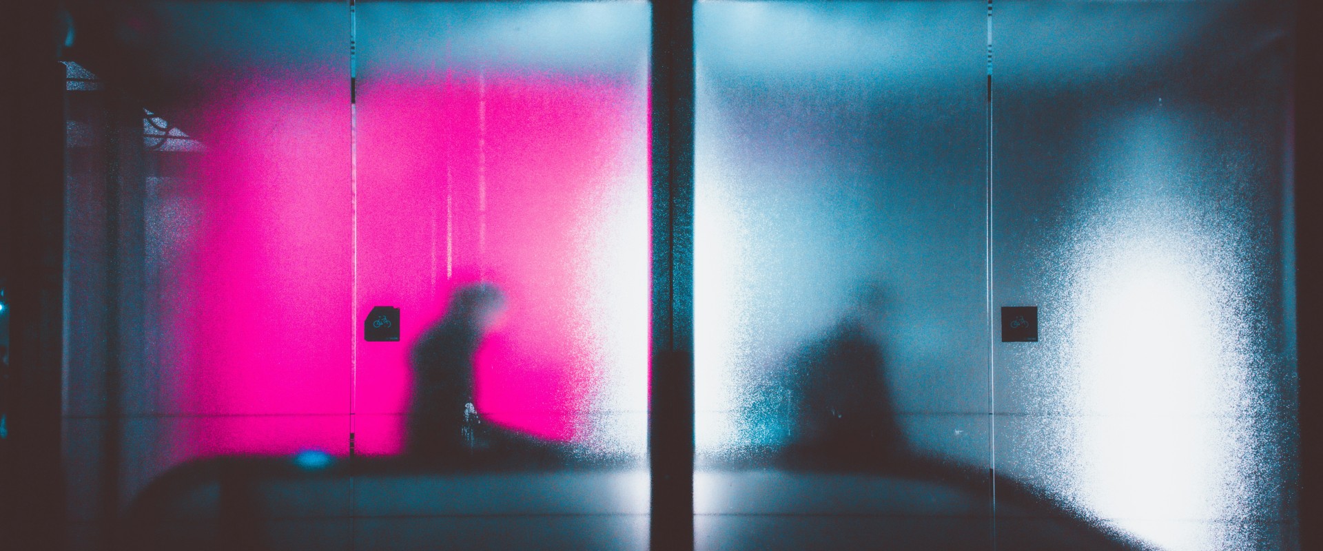 two human figures behind obscuring glass