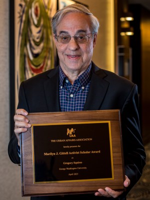 Gregory Squires holds the plaque honoring him as the Gittell Award winner