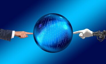 Human hand (left) and robot hand (right) touch a globe with a series of 1's and 0's on it.