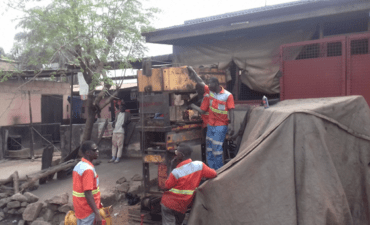 men in orange vests in informal workyard