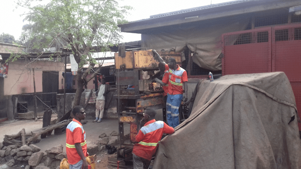 men in orange vests in informal workyard