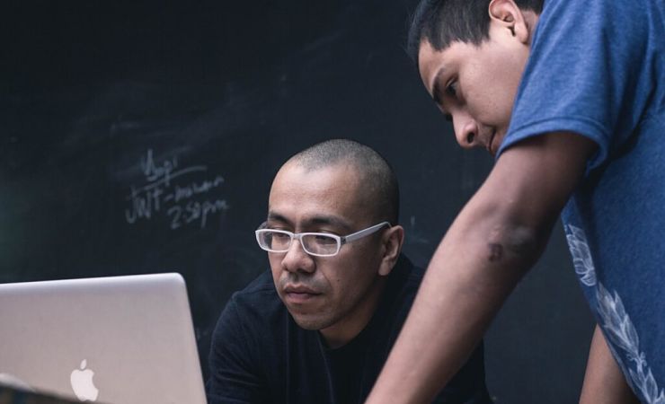 two researchers looking at laptop screen