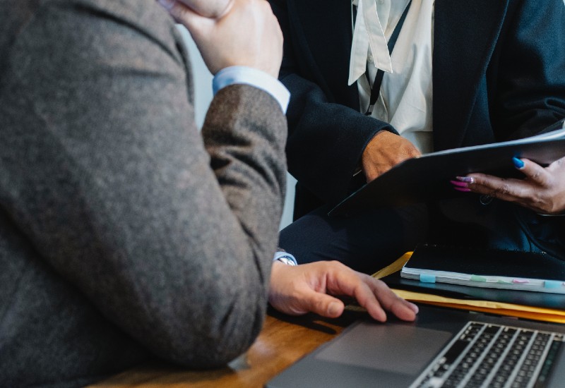 Close-up of woman reviewing figures in office with male colleague