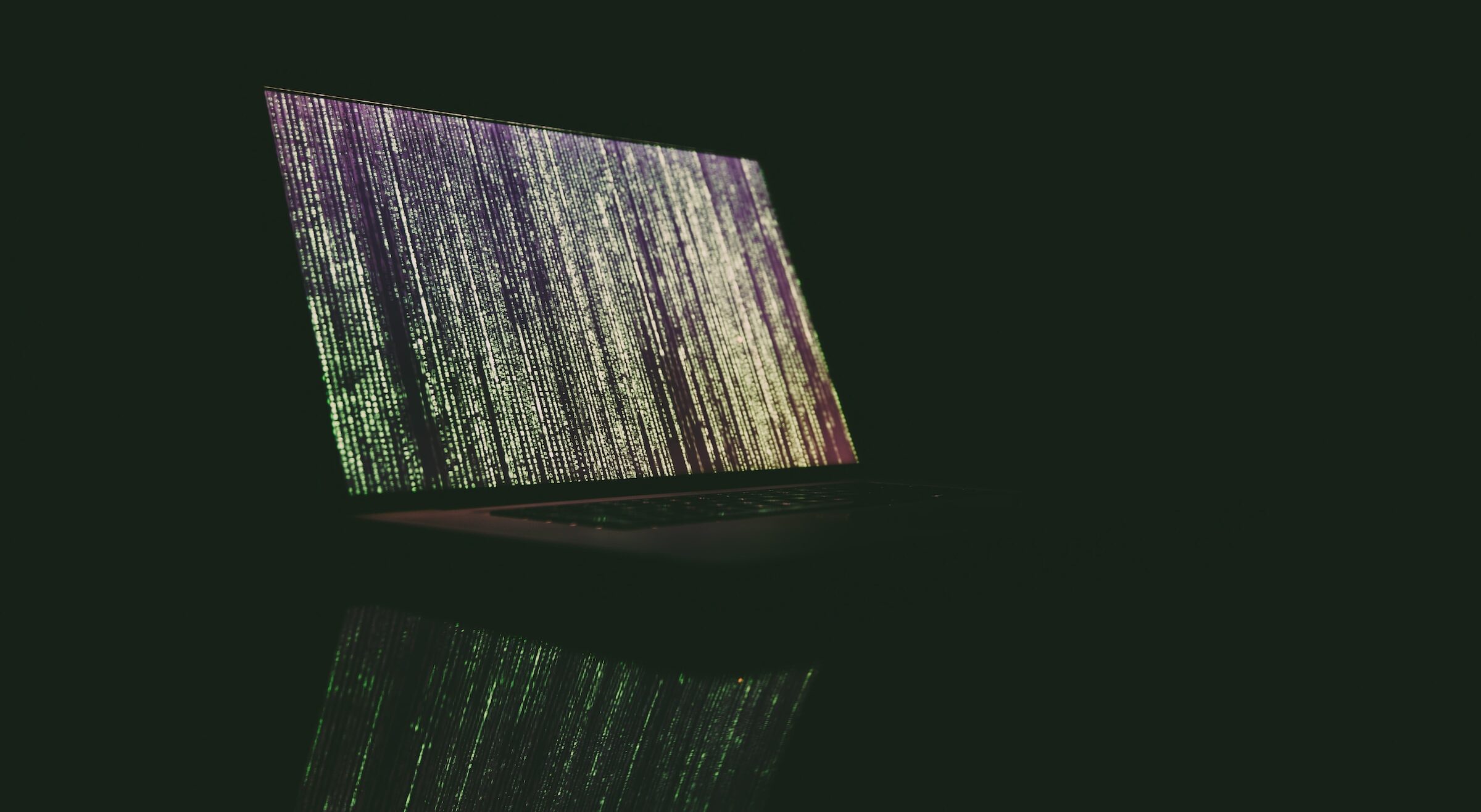 A computer screen against a dark background displays abstract lines of code