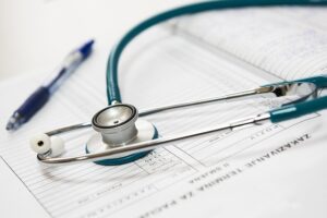 Stethoscope and pen on medical papers.