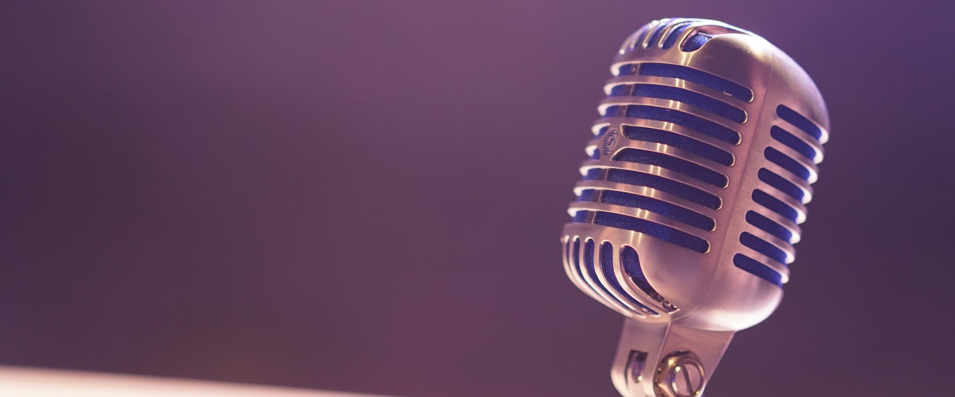 Closeup of old-fashioned microphone against solid color background