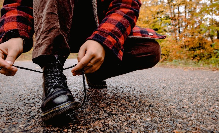 Hiker on forest path tying their bootlaces