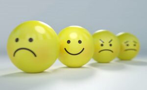 Four yellow balls with emoticon faces ranging from smiley to frowny to very sad