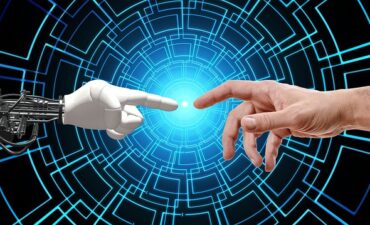 Robot finger and human finger pointed toward each other.